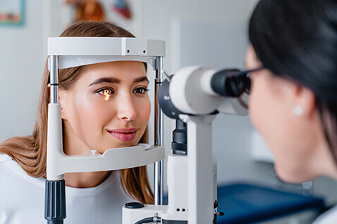 Woman having eye examined with slit lamp